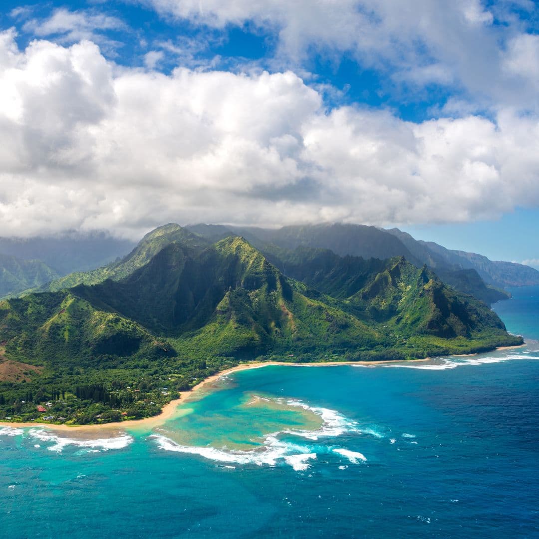 Aerial view of Kauai’s green cliffs, coastline and turquoise ocean